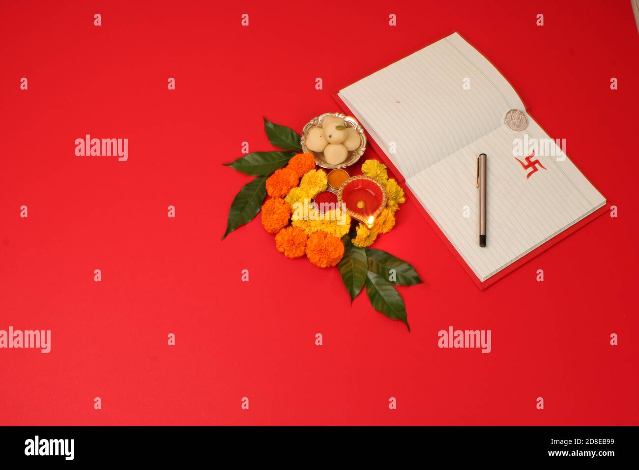 Libro di note di contabilità rossa / khata di bahi con diya, dolci, rangoli di marigold, haldi kumkum, penna con inchiostro su Laxmi pujan, Festival di Diwali Foto Stock