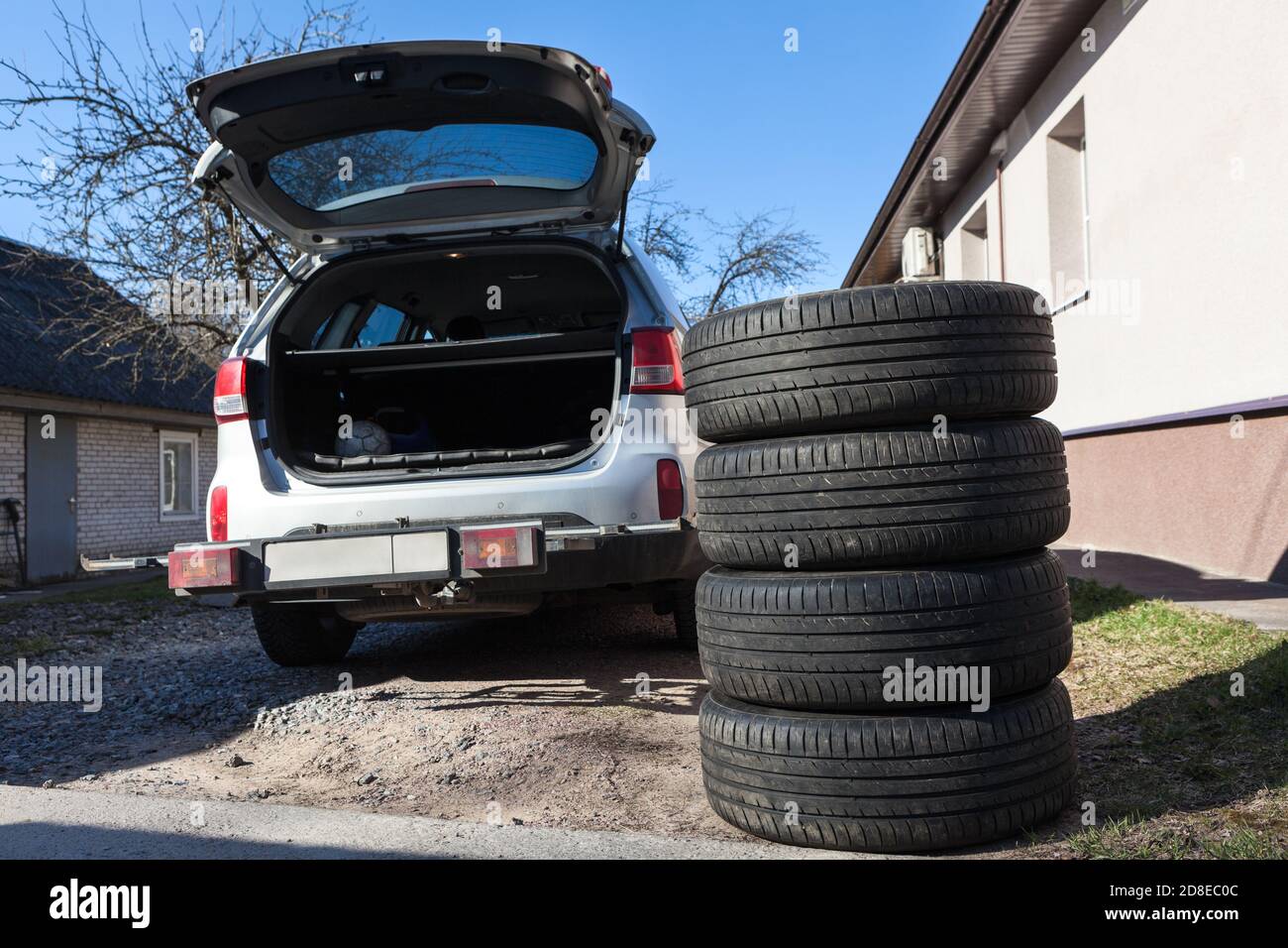 Cambio manuale degli pneumatici nella stagione primaverile, le ruote estive sono pronte per essere installate su un'auto suv Foto Stock