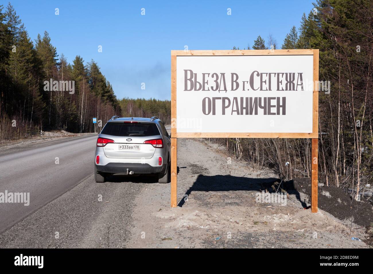 Carelia, Russia-10 aprile 2020: Un'auto con targhe della regione di San Pietroburgo si trova sul lato della strada, vicino al cartello con l'inscrimpio Foto Stock