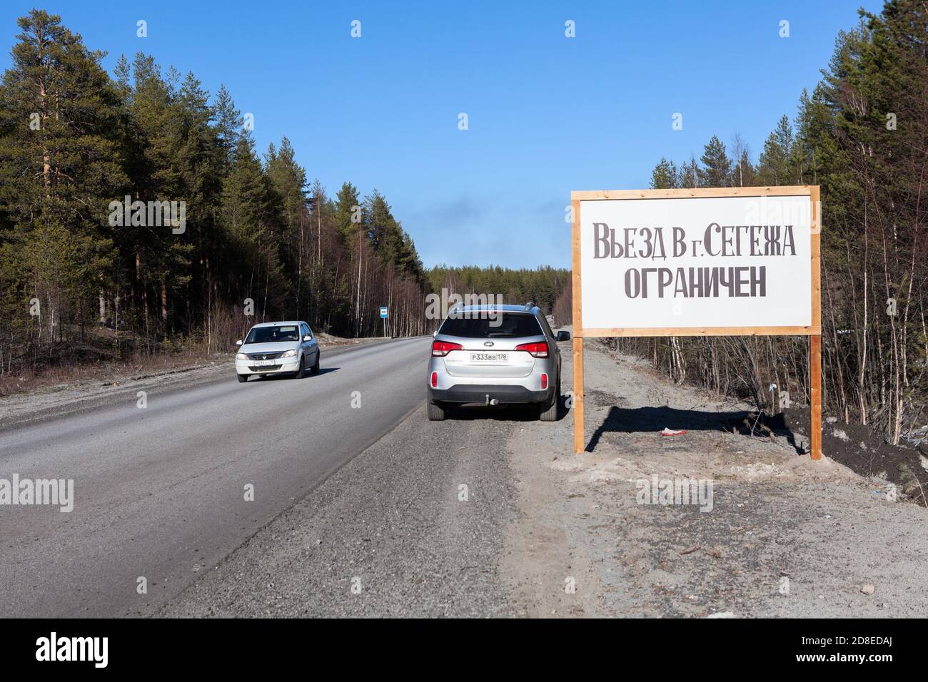 Carelia, Russia-10 aprile 2020: Un suv con targa della regione di San Pietroburgo si trova sul lato della strada, vicino al cartello con l'iscrizione Foto Stock