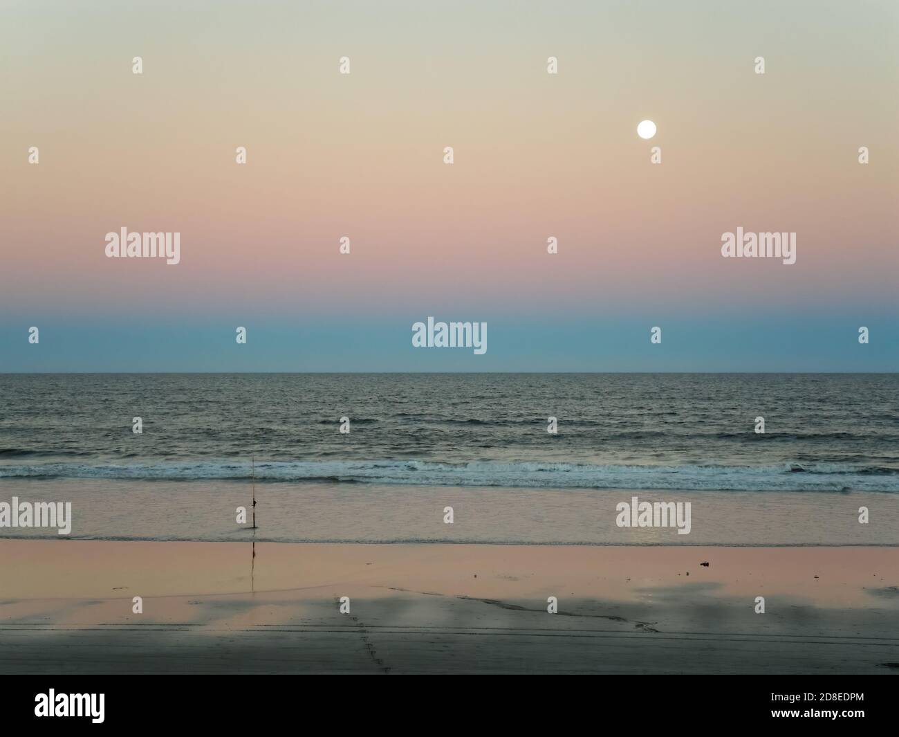 Luna piena sul mare al tramonto in spiaggia Foto Stock