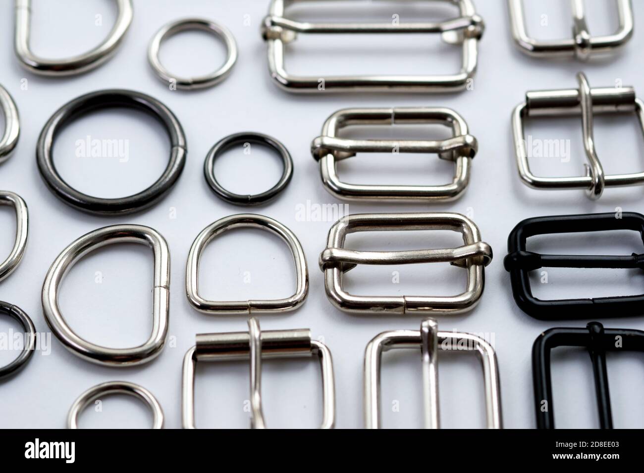 Anelli metallici, semianelli e cinghie su fondo bianco. Accessori in  metallo per la fabbricazione di zaini e borse Foto stock - Alamy