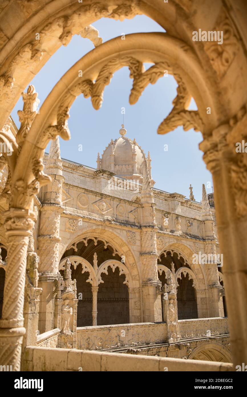 Architettura e archi decorati manuelini con vista sul campanile a cupola nel chiostro del Monastero di Jerónimos a Lisbona, Portogallo, Europa. Foto Stock