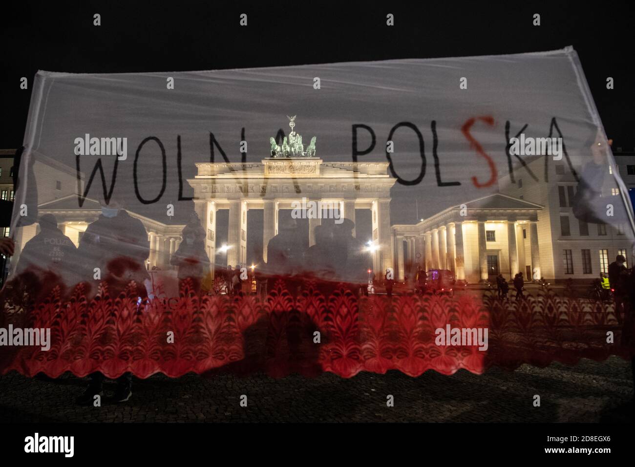 Berlino, Germania. 29 Ott 2020. 'Wolna Polska' (Polonia libera) è scritto su un banner di fronte alla porta di Brandeburgo. I manifestanti hanno protestato contro un inasprimento del divieto di aborto in Polonia. Credit: Paul Zinken/dpa-Zentralbild/dpa/Alamy Live News Foto Stock