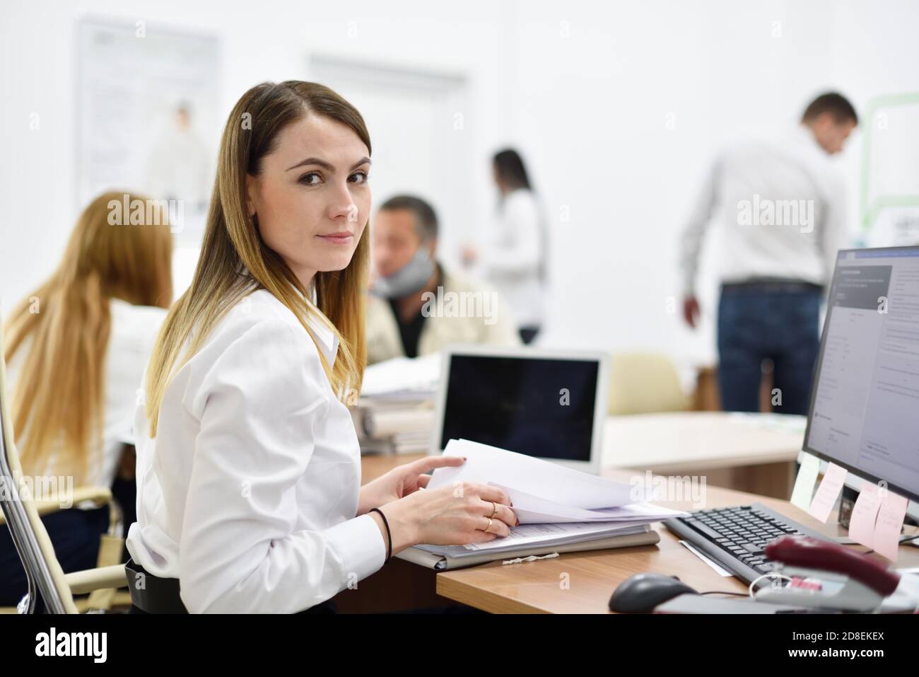 Ritratto di una donna di mezza età responsabile dell'ufficio sul posto di lavoro in ufficio con persone Foto Stock