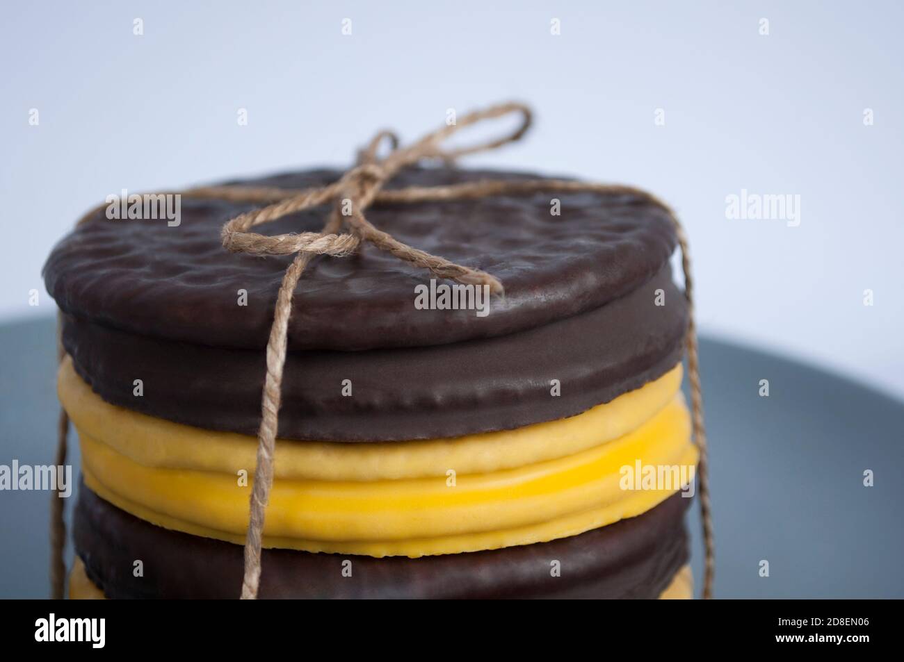 Pila di biscotti rotondi ricoperti di cioccolato giallo e scuro, assortiti Foto Stock