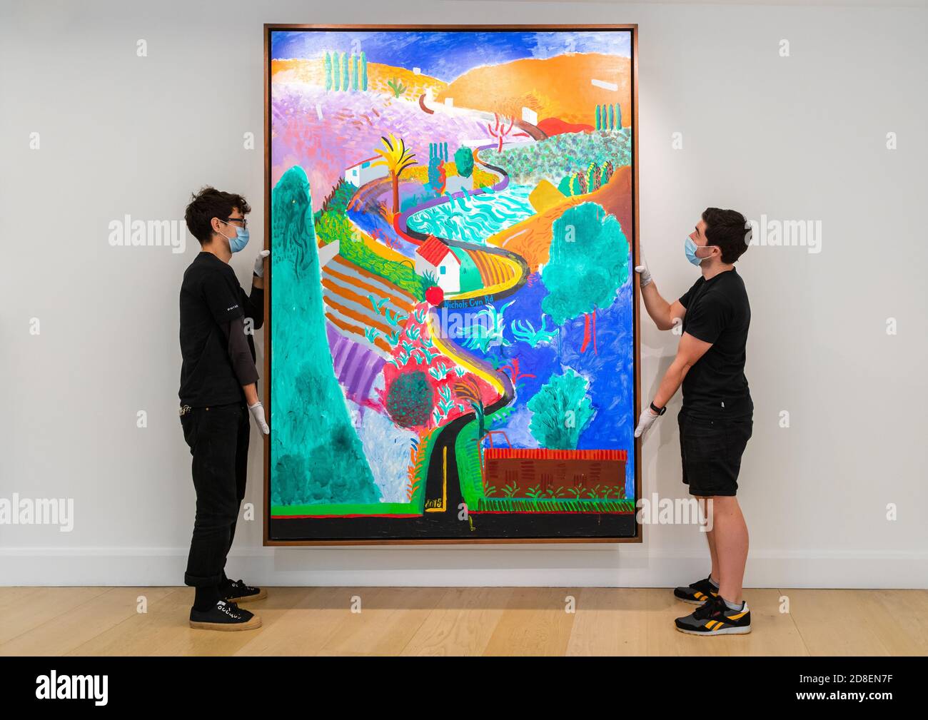 Londra, Regno Unito. 29 ottobre 2020. Il personale della Gallery posa con la pittura paesaggistica 'Nichols Canyon' di David Hockney, il paesaggio più importante mai apparso all'asta nella casa d'aste di Phillips a Berkley Square, Londra. Si stima che il paesaggio di Hockney intitolato 'Nichols Canyon' venderà per 35 milioni di dollari al 20° secolo di New York e alla vendita serale di arte contemporanea il 7 dicembre. Foto Stock