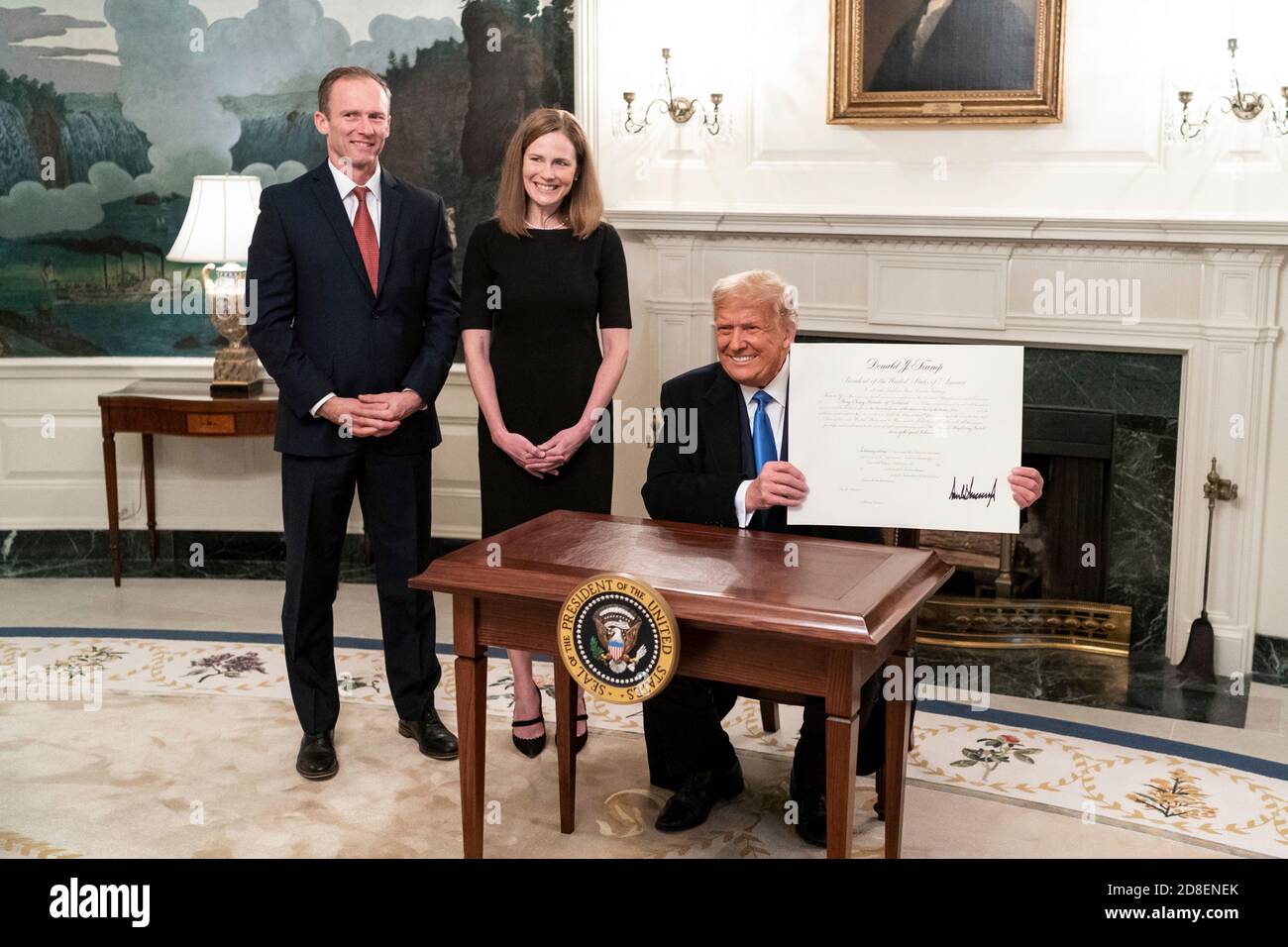 Il presidente degli Stati Uniti Donald Trump mostra il certificato della commissione che conferma il giudice Amy Coney Barrett alla Corte Suprema durante una cerimonia nella Sala di accoglienza diplomatica della Casa Bianca il 26 ottobre 2020 a Washington, DC. Da sinistra a destra ci sono: L'associato della Corte Suprema Clarence Thomas, Jesse Barrett, l'associato della Corte Suprema Amy Coney Barrett, il presidente Donald Trump, la First Lady Melania Trump e il consulente della Casa Bianca Pat Cipollone. Foto Stock