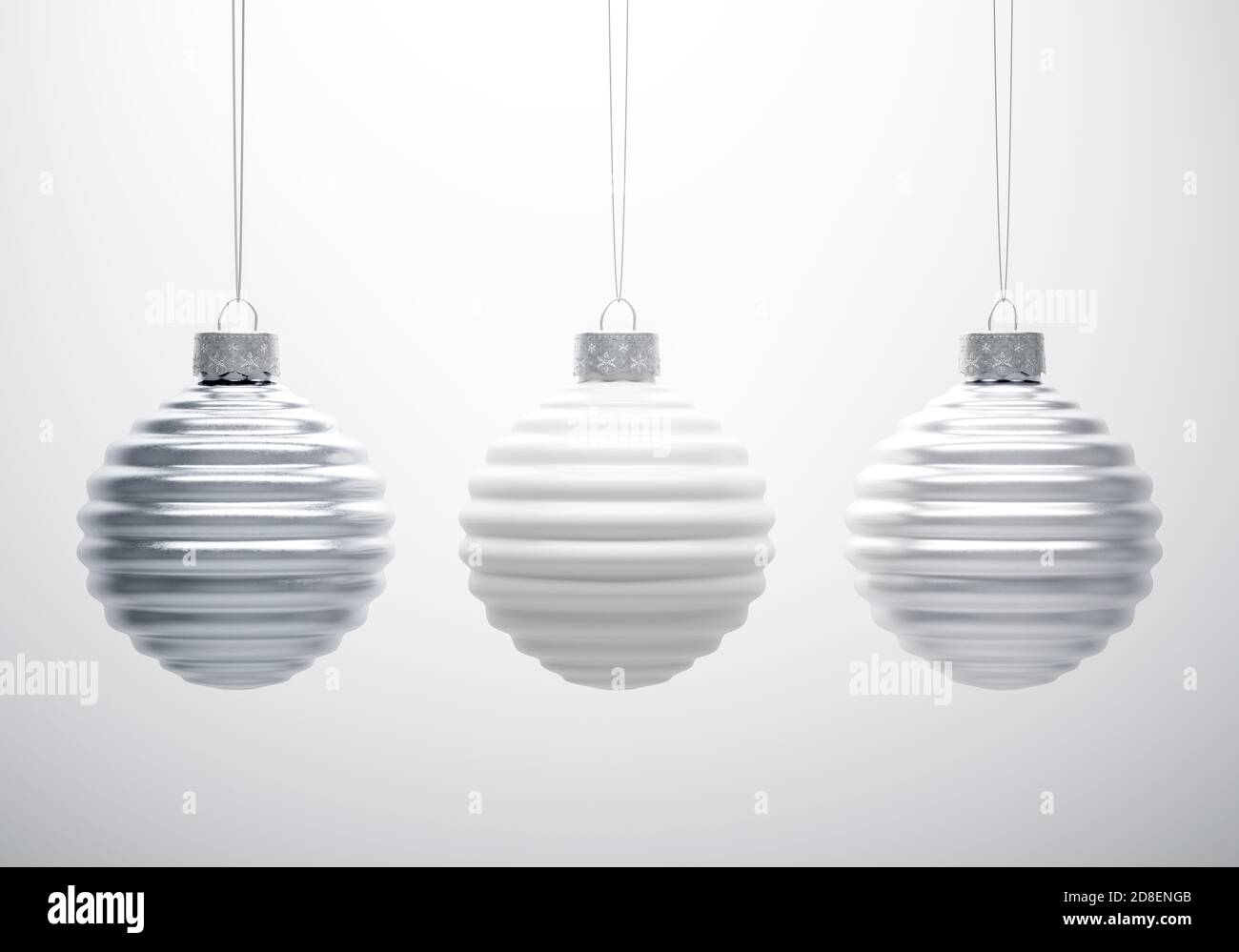 Composizione in bianco e nero di tre palle di Natale a coste orizzontali appese in linea su sfondo bianco. Decorazione di Natale, atmos festa Foto Stock