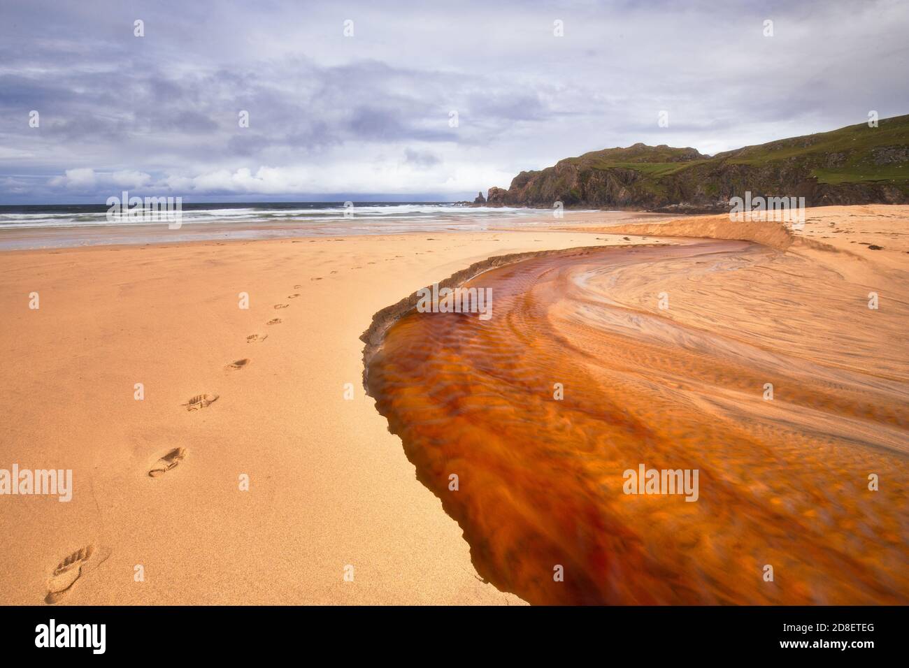 Il fiume rosso scende fino alla spiaggia di Dalmore Isola di Lewis Foto Stock