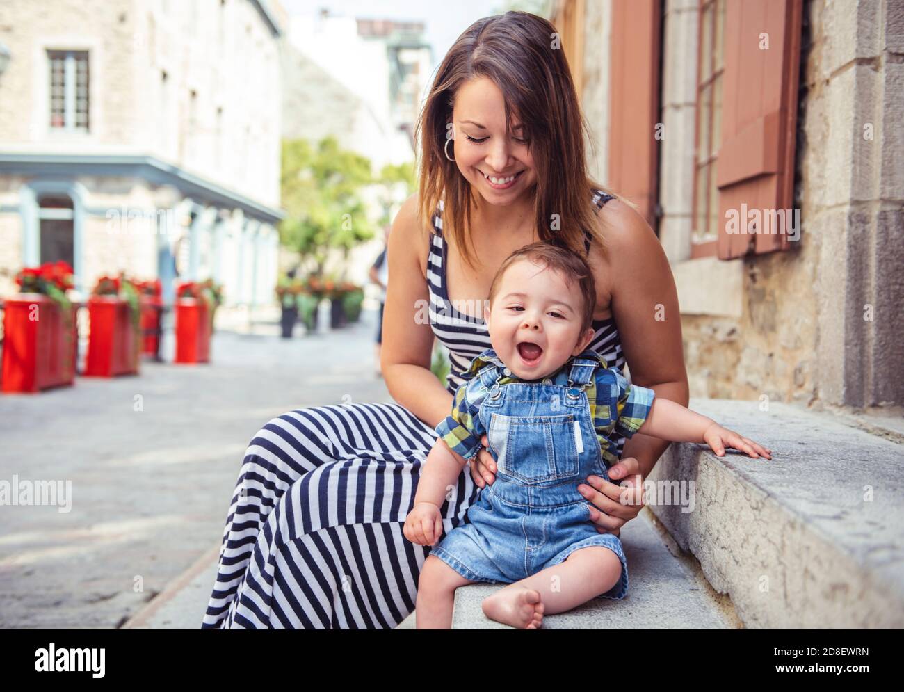 Una Madre con il suo figlio su un fondo urbano Foto Stock