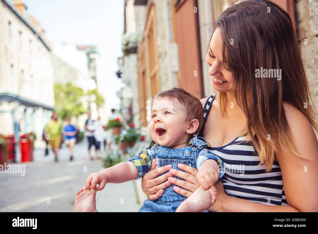 Una Madre con il suo figlio su un fondo urbano Foto Stock