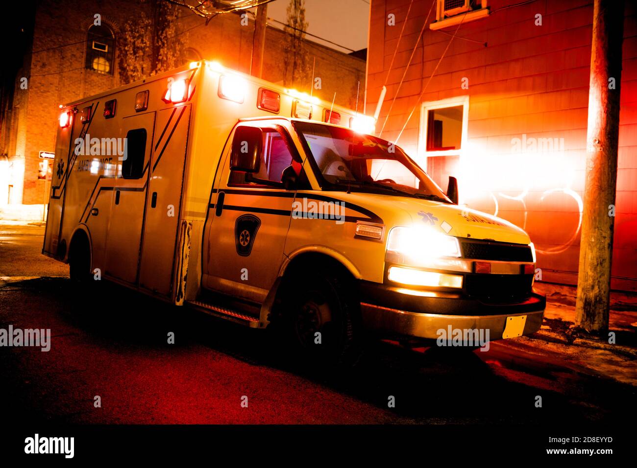Un'auto ambulanza parcheggiata sulla strada laterale di notte Foto Stock