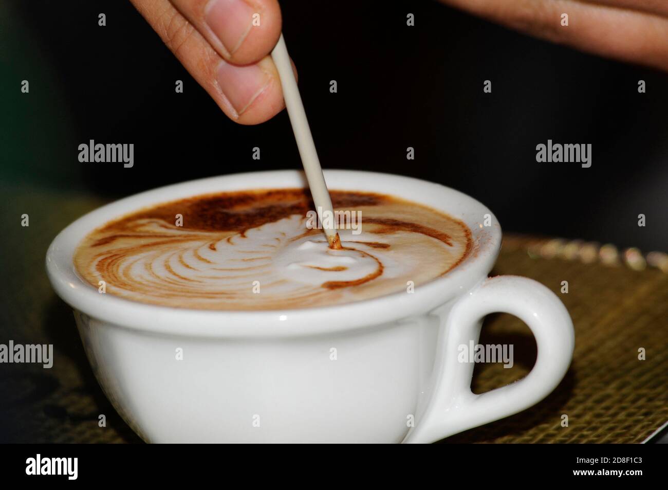 una tazza di caffè con latte, mescolando con il cucchiaio per il tè Foto Stock