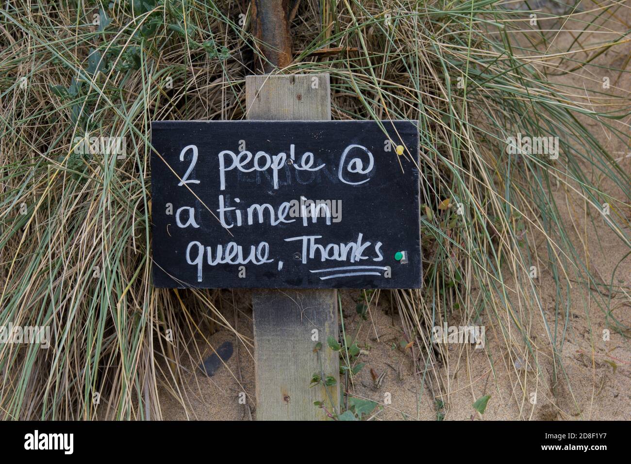 Cartello d'ingresso al Poldhu Beach Cafe durante la crisi del Covid 19 richiedere l'allontanamento sociale nelle code Foto Stock