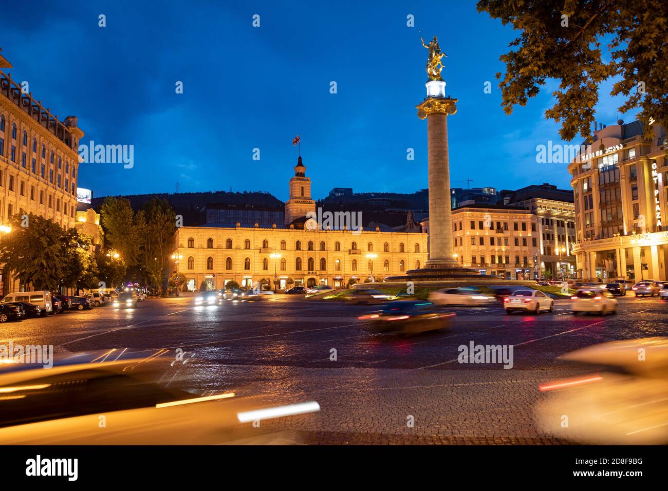 Scena notturna del traffico che circonda la statua di San Giorgio a Piazza della libertà (Piazza della libertà) a Tbilisi, Georgia, Caucaso, Europa orientale. Foto Stock