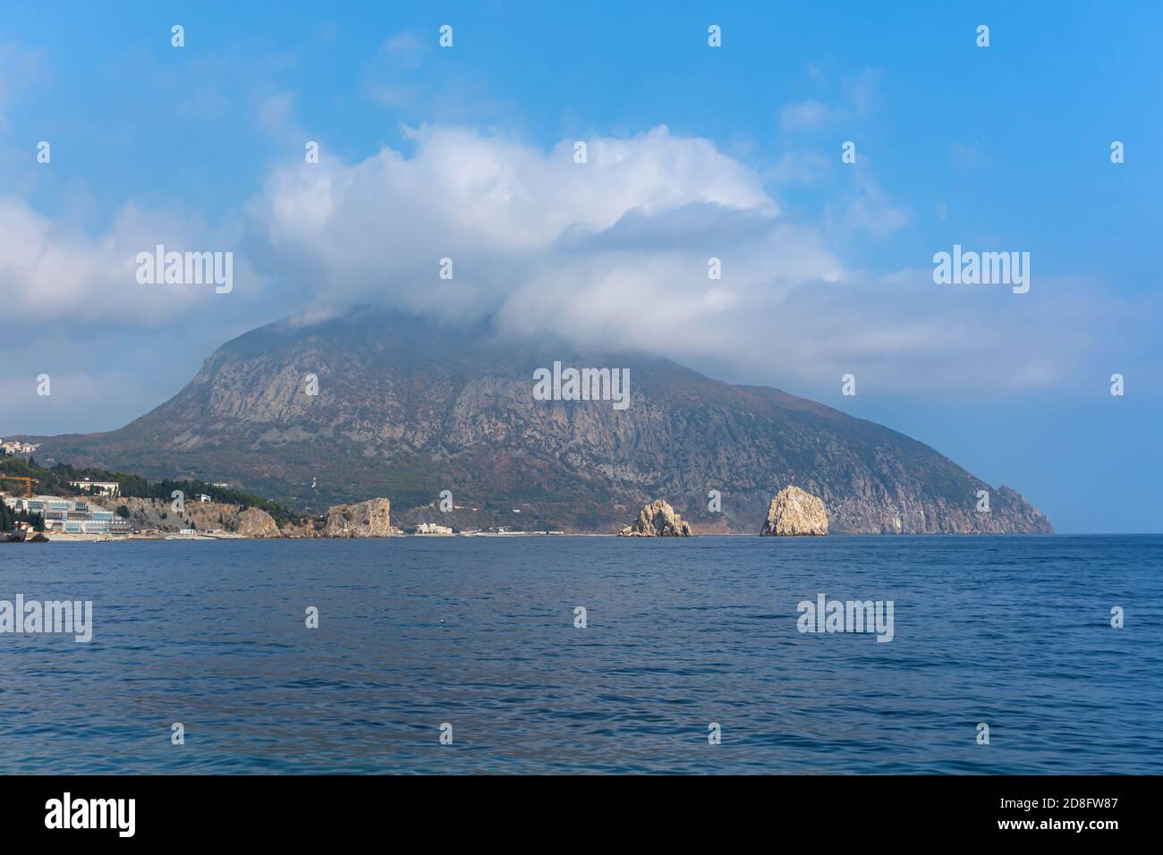 Mount Bear Ayu-Dag sotto le nuvole da vicino. Vista delle rocce di adalara ai piedi della montagna e la costruzione del campo per bambini Artek. Au Foto Stock
