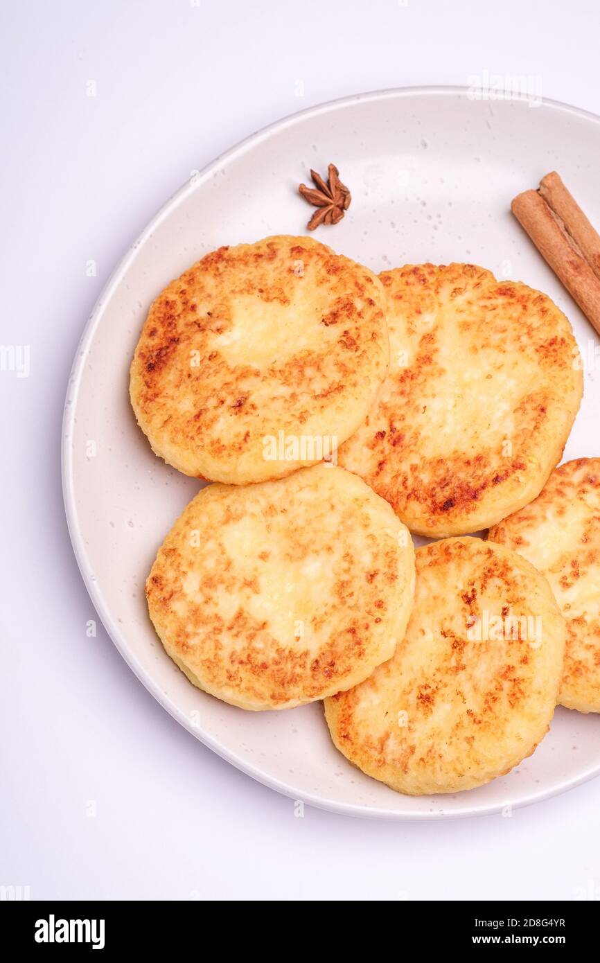 Frittelle di formaggio di cottage. Colazione di Natale con anice e cannella su sfondo bianco, vista dall'alto Foto Stock