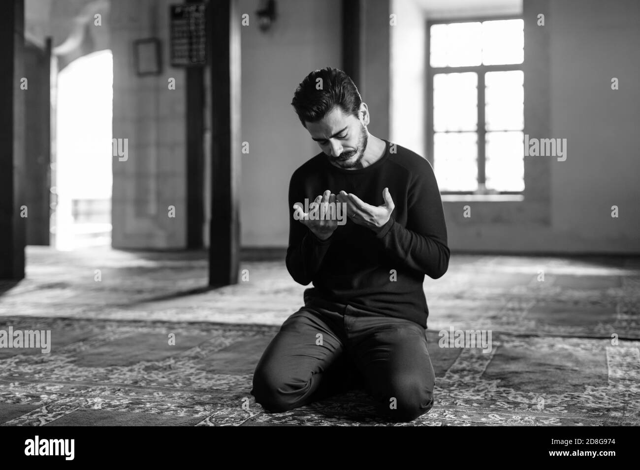 Giovane uomo mustached che prega in Moschea Foto Stock