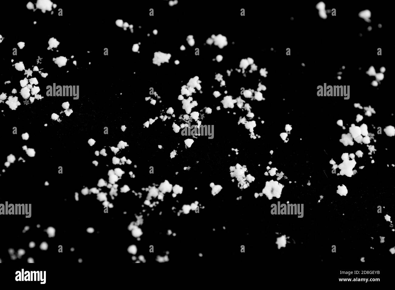 Molti fiocchi di neve su uno sfondo nero, l'immagine di sfondo assomiglia a un cielo stellato scuro Foto Stock