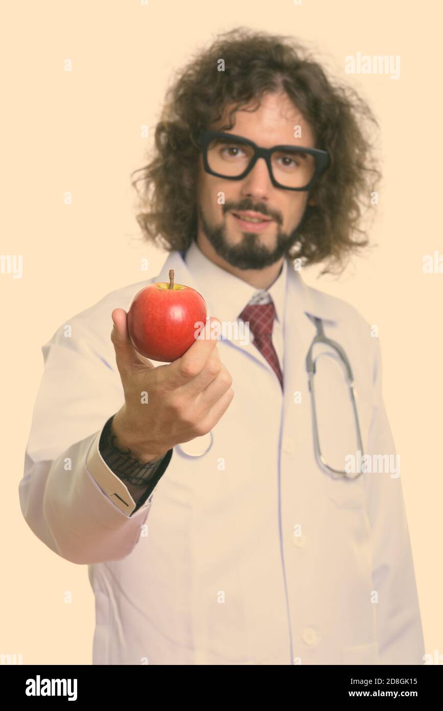 Studio shot di uomo bello medico dando red apple con focus su apple Foto Stock