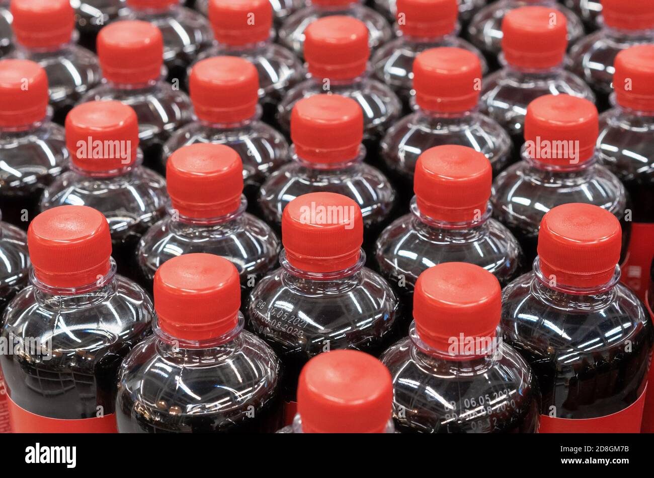 Bottiglie di plastica con bevande gassate e tappi rossi. Foto Stock