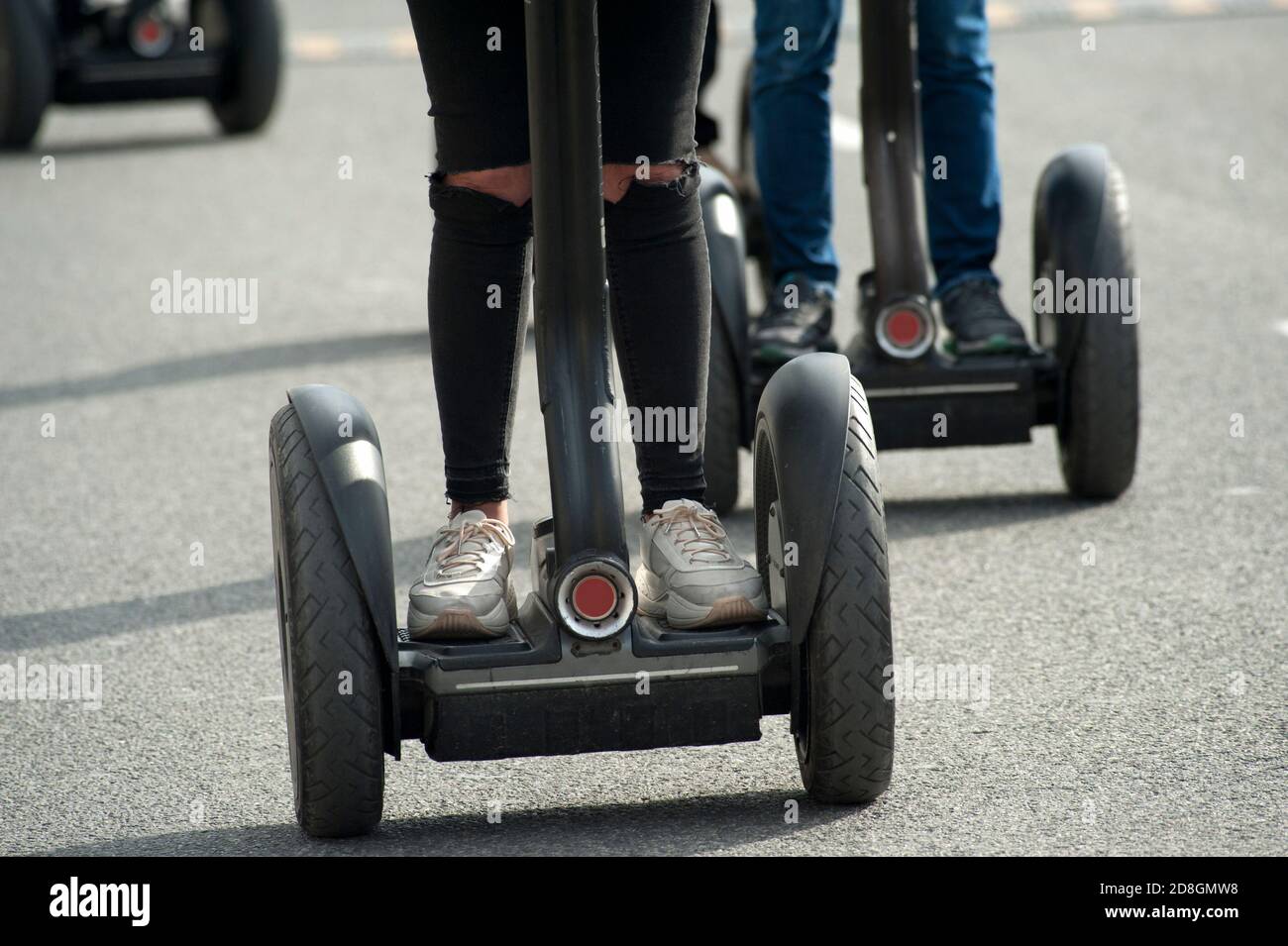 donna su scooter elettrico con pantaloni neri e scarpe bianche Foto stock -  Alamy