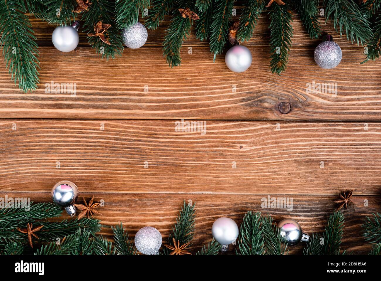 Piatto con rami di pino, palle di natale e stelle di anice su sfondo di legno marrone Foto Stock