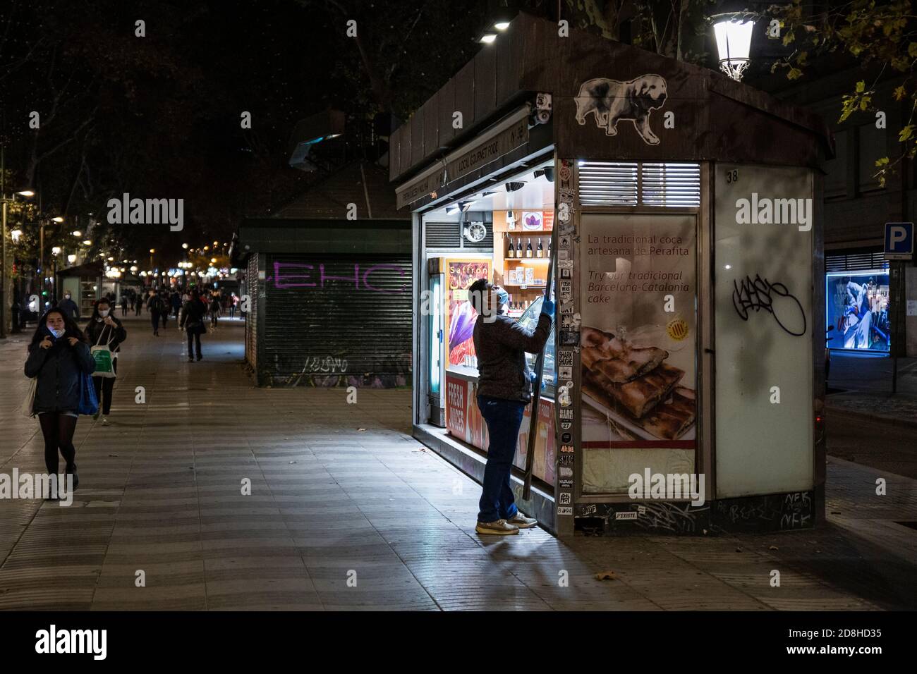 Barcellona, España. 29.10.2020. L'operaio di un negozio sulle Ramblas di Barcellona raccoglie per chiudere, rispettando il nuovo limite di tempo di coprifuoco. Foto Stock