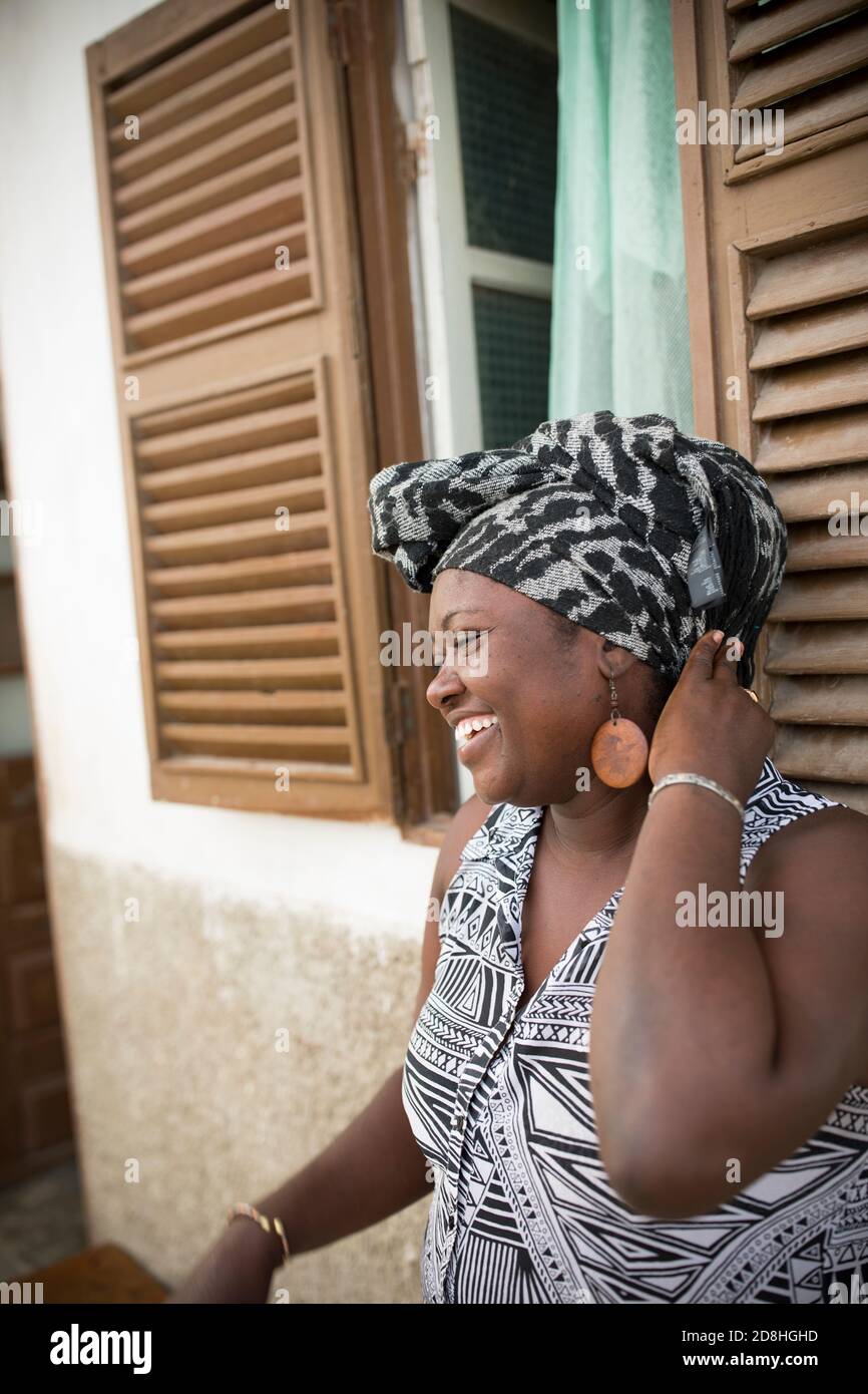 Ritratto di una bella donna africana che ride con gioia fuori dalla sua casa sull'isola di Maio, Capo Verde, Africa. Foto Stock