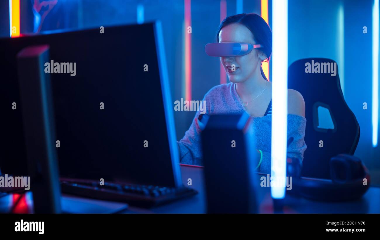 Bella Pro Gamer Girl indossare Virtual Reality Headset e gioca in Online Video Game. Colori retro Neon in camera. Foto Stock