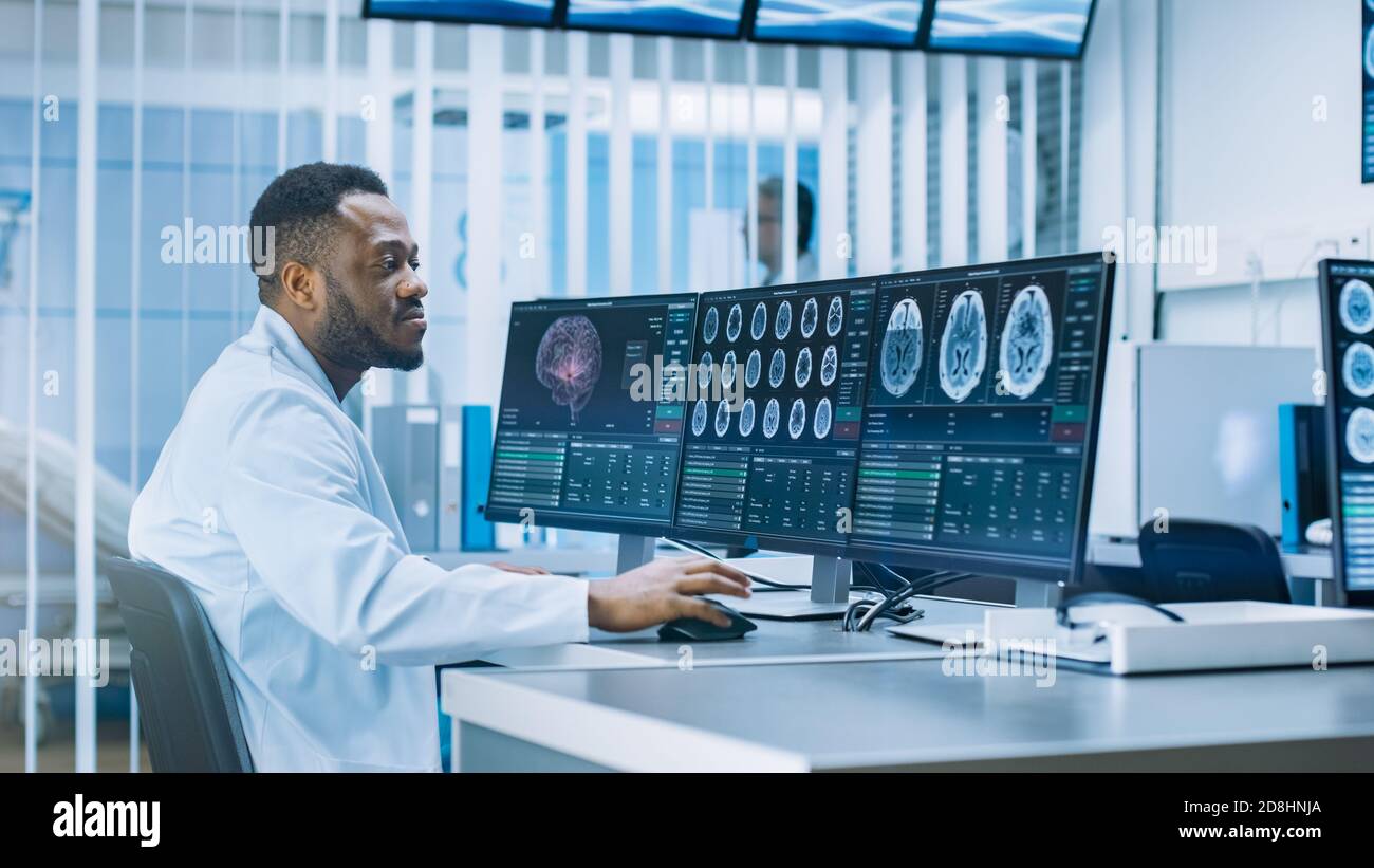 Medico scienziato che lavora con immagini TAC Brain Scan su un personal computer in laboratorio. Neurologi in Neurological Research Center che lavorano su un Foto Stock