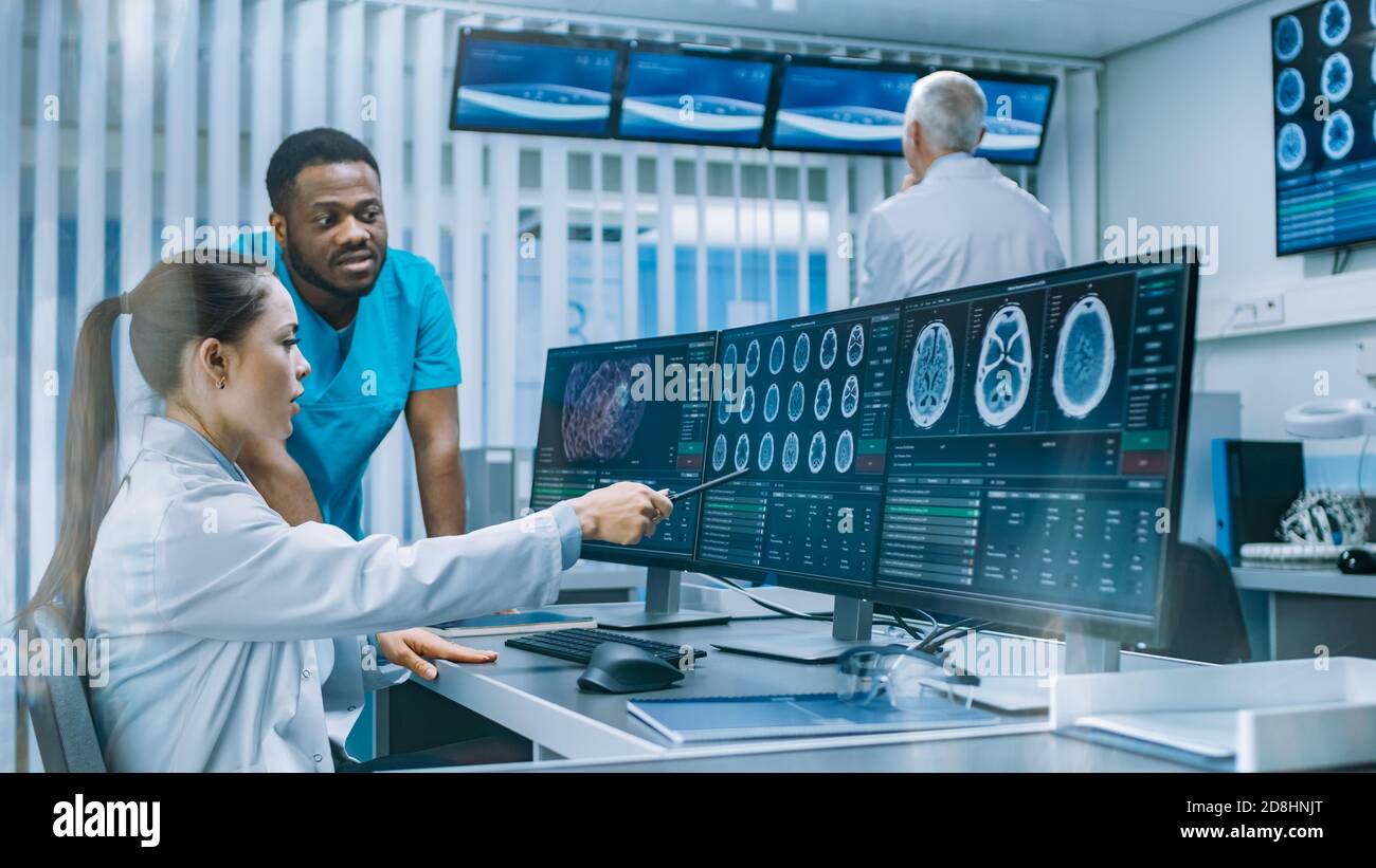 Medico scienziato e chirurgo che discute immagini TAC Brain Scan su un personal computer in laboratorio. Neurologi neuroscienziati in neurologia Foto Stock