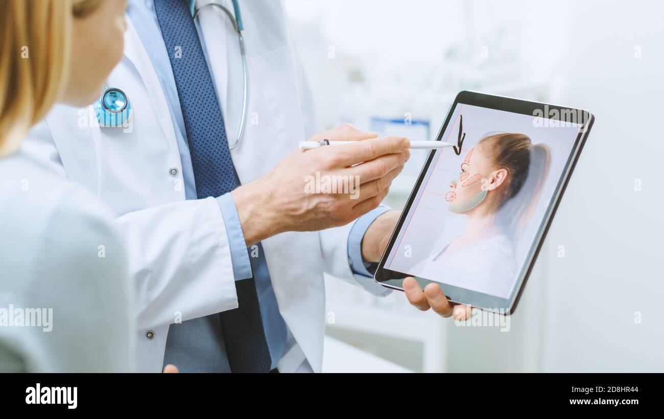 Il chirurgo cosmetico di plastica consulta la donna circa Chirurgia dell'elevatore facciale, punta allo schermo del calcolatore del Tablet digitale che mostra i tipi di lifting, fronte Foto Stock