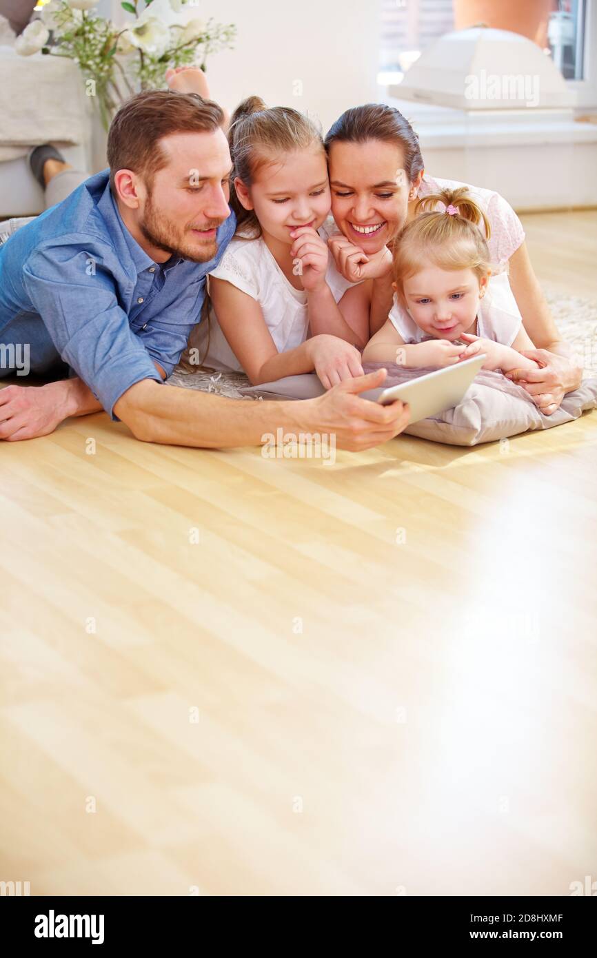 La famiglia guarda un video sul tablet con i bambini Foto Stock