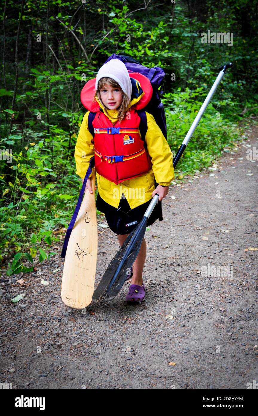 I piccoli viaggiatori portano le attrezzature sul portage mentre si allontana nel PARCO Provinciale Algonquin dell'Ontario, ONTARIO, CANADA. Foto Stock