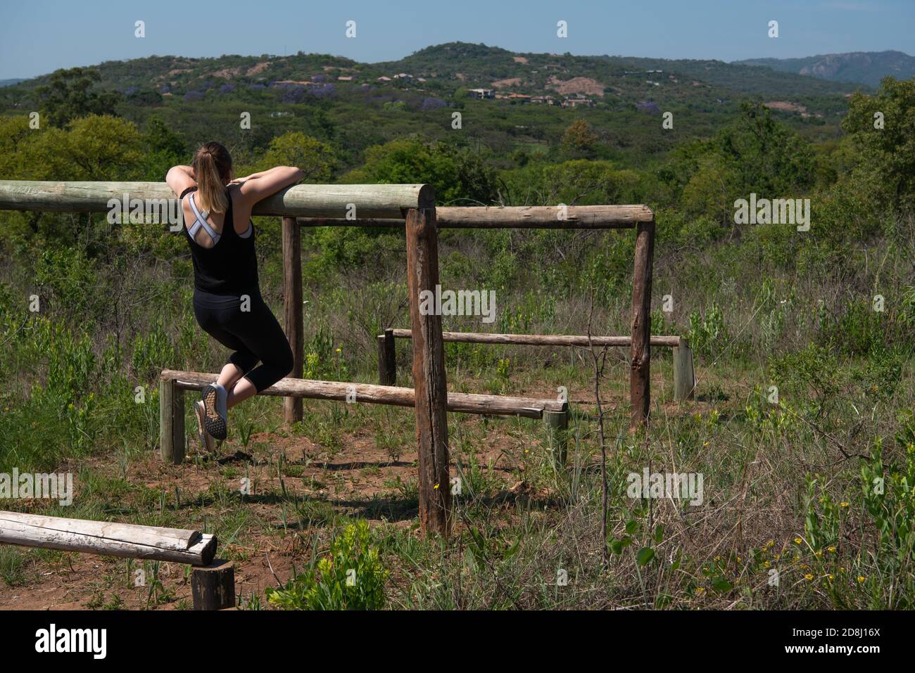 Una giovane donna che fa una routine di esercizio all'aperto Foto Stock