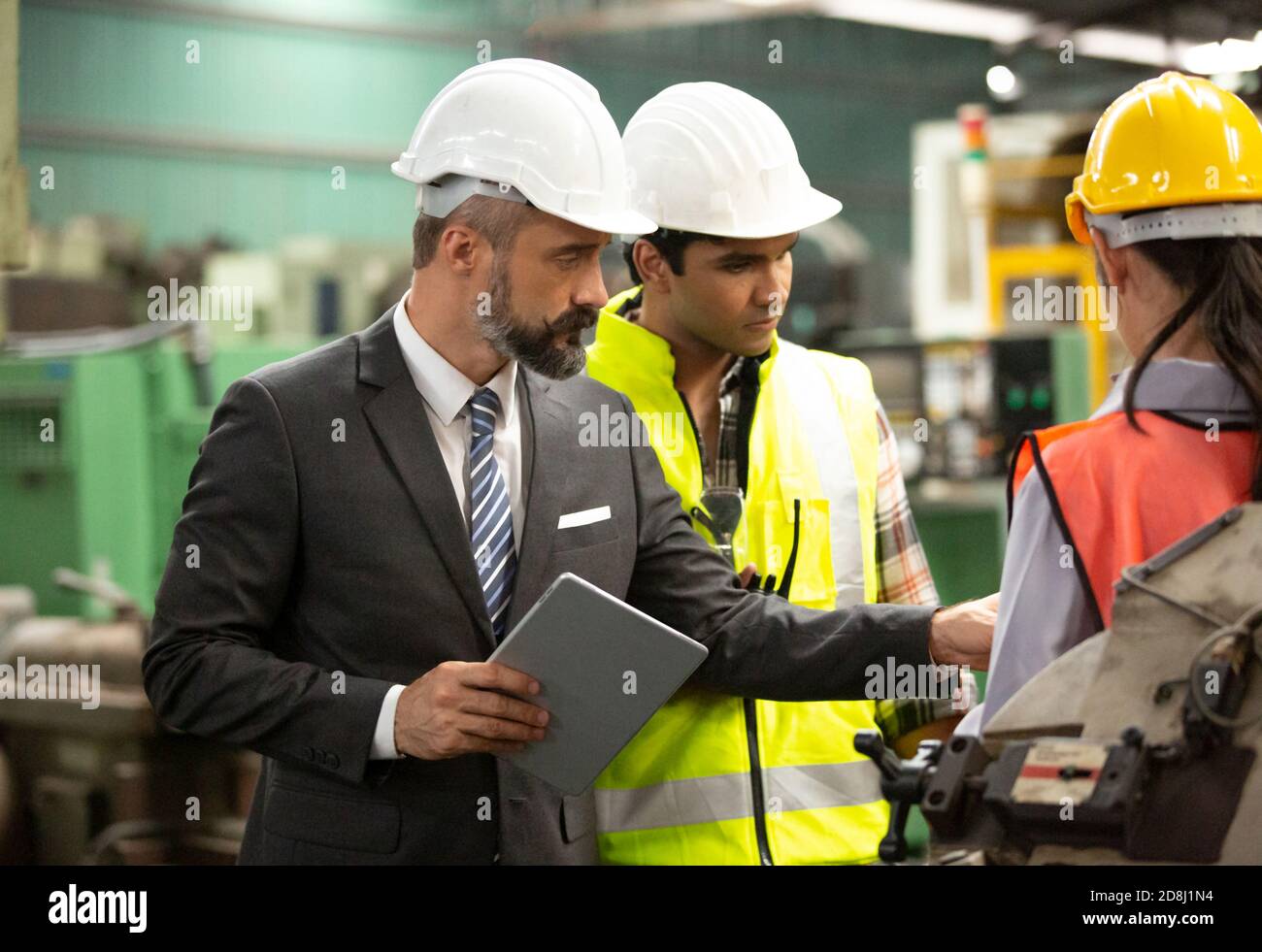Gli ingegneri industriali maschili parlano con i lavoratori della fabbrica . Lavorano presso lo stabilimento di produzione dell'industria pesante. Foto Stock