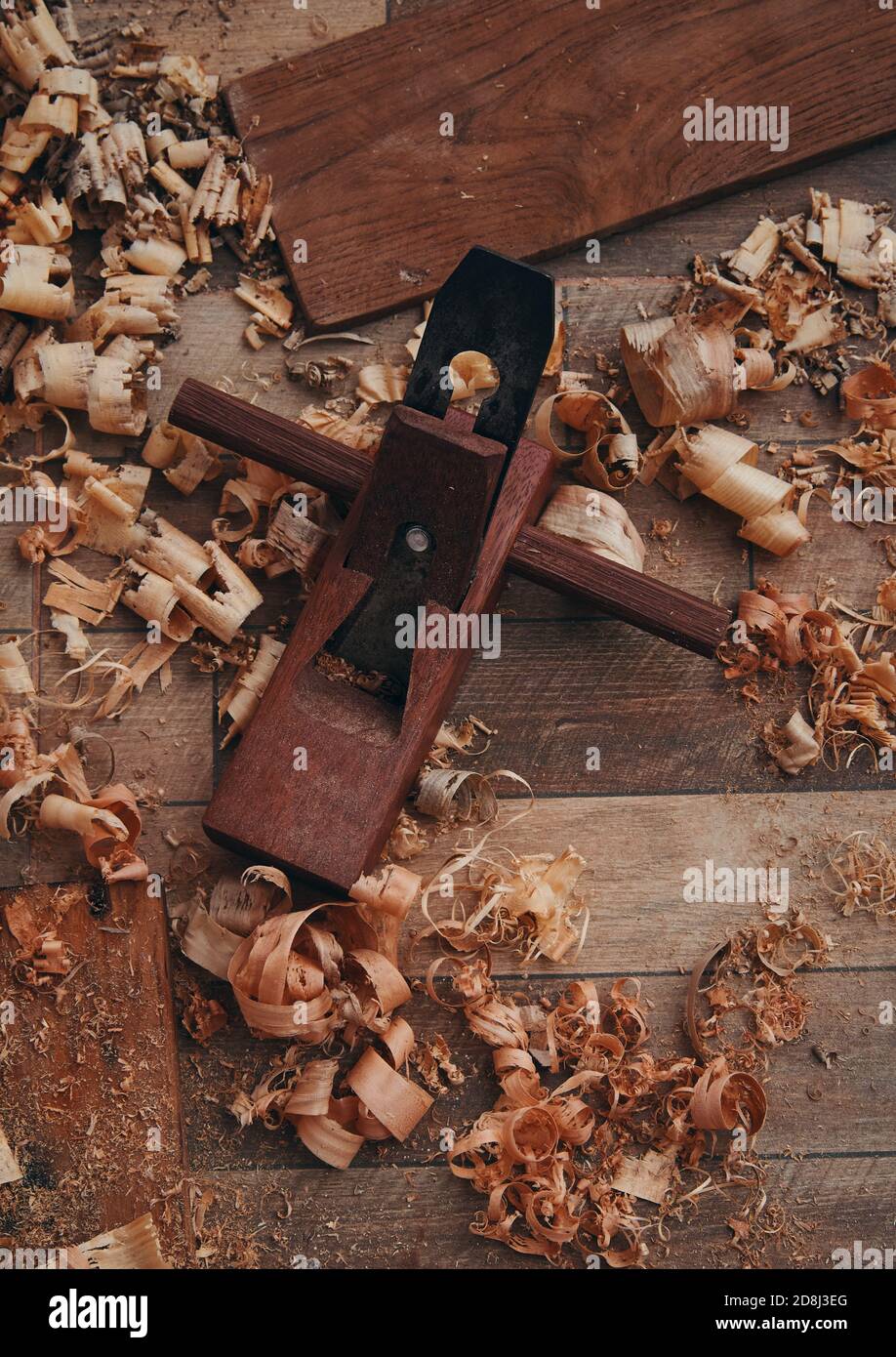 Una piallatrice manuale e trucioli di legno sul pavimento in piastrelle Foto Stock