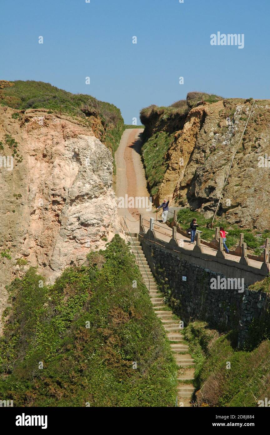 Parte di la Coupée che guarda da Little Sark a Sark, mostrando i gradini che conducono a la Grande Greve, la spiaggia di sabbia sottostante. Foto Stock