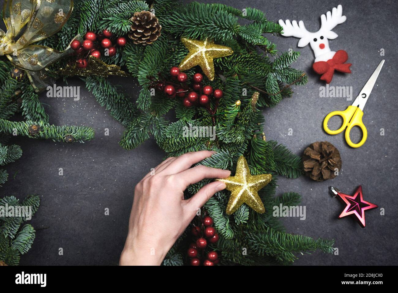 fare la corona di natale con rami di abete e decorazioni. Sfondo nero Foto Stock