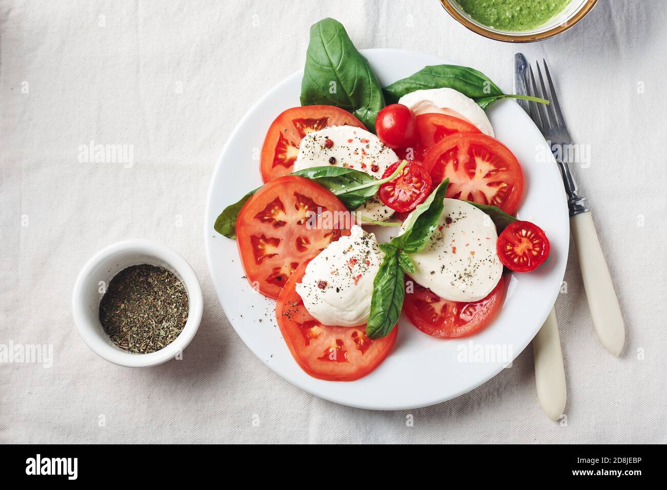 Insalata caprese. Pomodori, mozzarella, foglie di basilico e salsa al pesto. Foto Stock