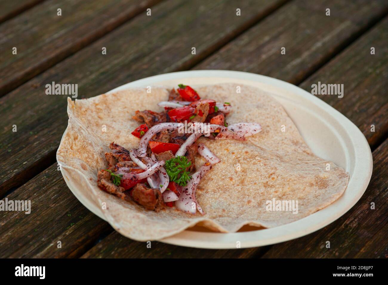 pezzi di adana kebab alla griglia al carbone vengono messi su una tortilla di farina fatta in casa e mescolati con pomodoro condito, cipolla, prezzemolo mix. La miscela deve essere Foto Stock