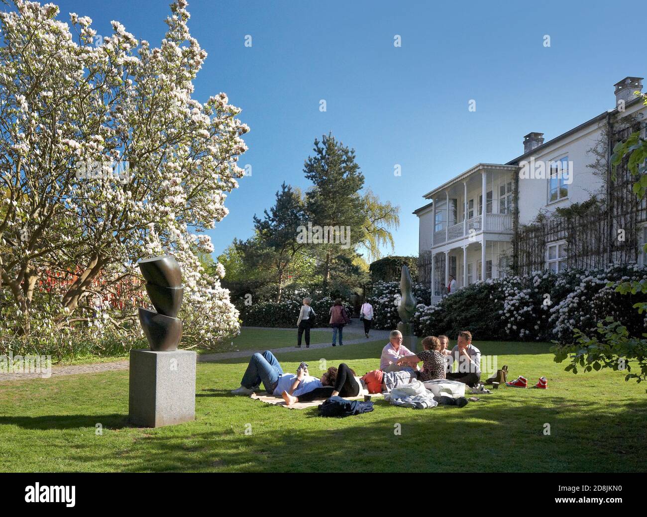 Persone che si rilassano sul prato fuori del Louisiana Museum of Modern Art in Danimarca. Foto Stock