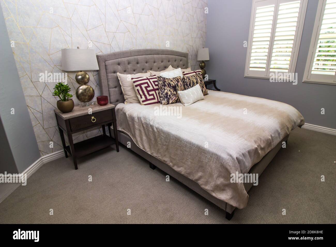 Camera con letto, tavoli da notte e lampade moderne Foto Stock