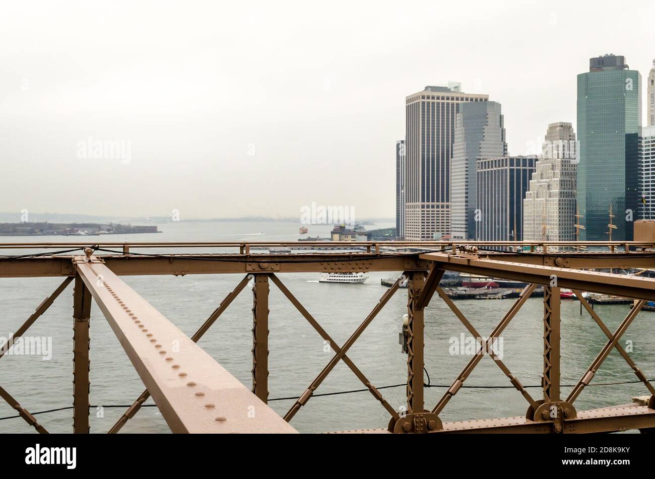 Vista dei grattacieli e degli edifici di Lower Manhattan, dei Piers e della Statua della libertà che svanisce a Fog. Scatto preso dal ponte di Brooklyn Foto Stock