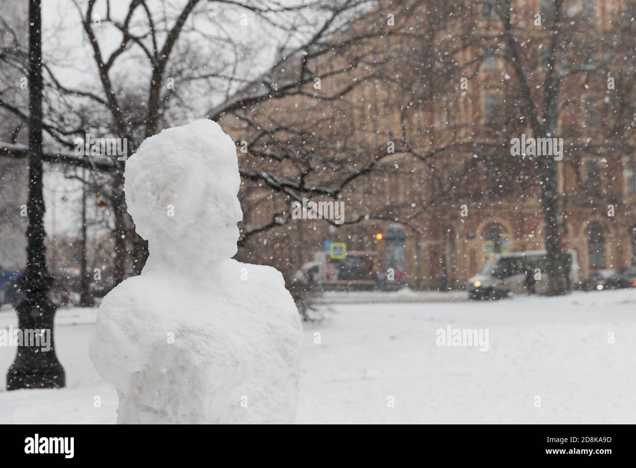 Pupazzo di neve con volto umano durante una nevicata a San Pietroburgo. Concetto di tempo invernale Foto Stock