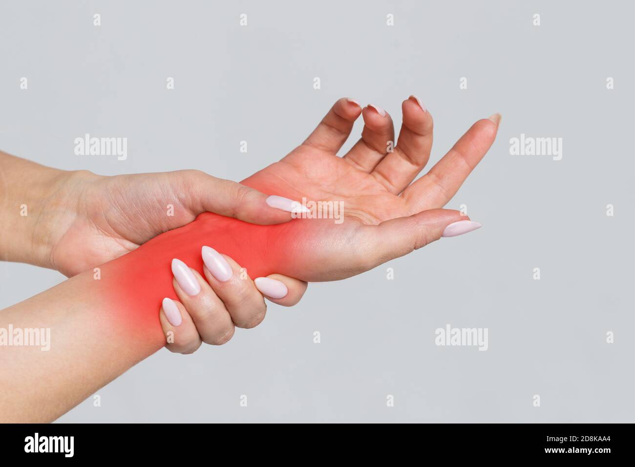 Le braccia femminili che tengono il polso doloroso causato da un lavoro prolungato sul computer, il laptop, di colore rosso. Sindrome del tunnel carpale, artrite, neurologico Foto Stock