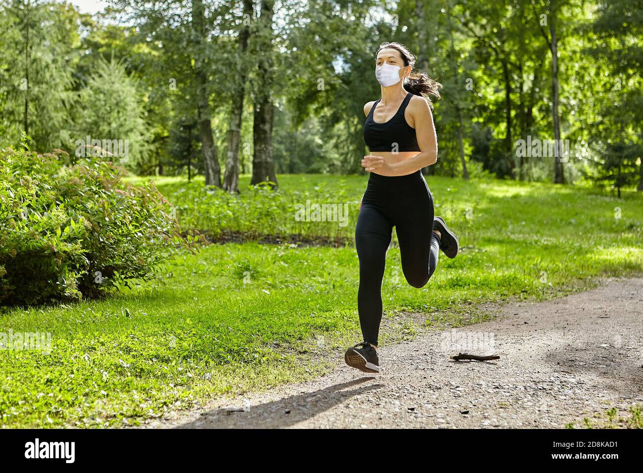 Donna bianca in maschera medica da covid-19 pandemic corre all'aperto. Foto Stock