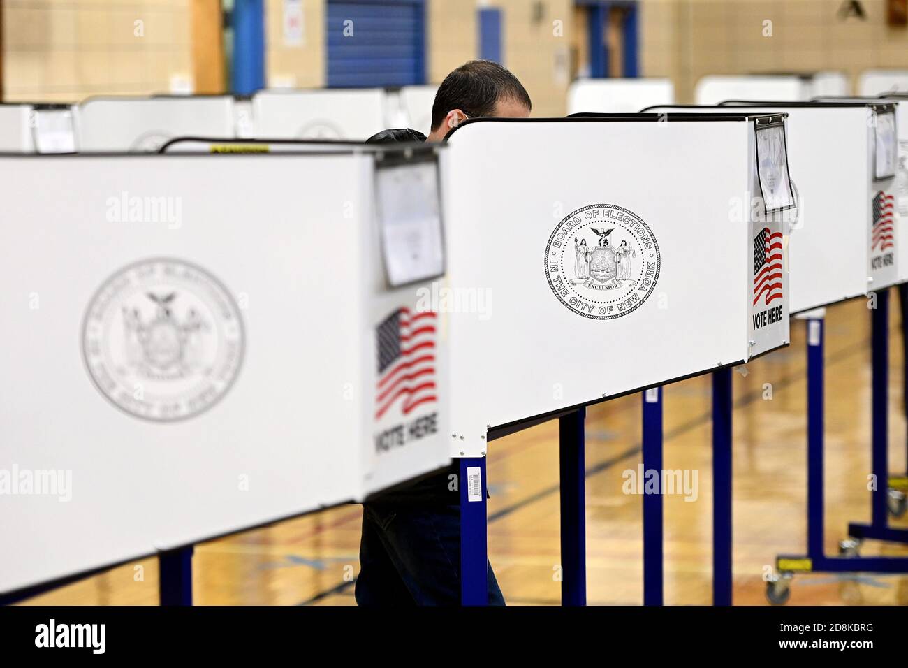 New York City, Stati Uniti. 30 Ott 2020. Le persone si levano in piedi dietro una cabina di privacy degli elettori per compilare i voti durante le prime elezioni presidenziali del 2020, all'interno della Robert Wagner Middle School sul lato Upper East di Manhattan, New York, NY, 30 ottobre 2020. La scuola e gli altri siti di voto del lato superiore orientale sono stati sovraccaricati da lunghe code e da un numero inferiore di scanner per schede elettorali necessari. (Anthony Behar/Sipa USA) Credit: Sipa USA/Alamy Live News Foto Stock